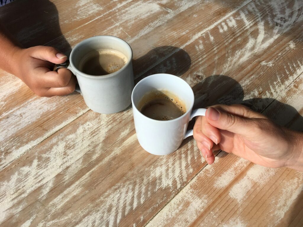 Coffee date, close up of hands on coffee mugs